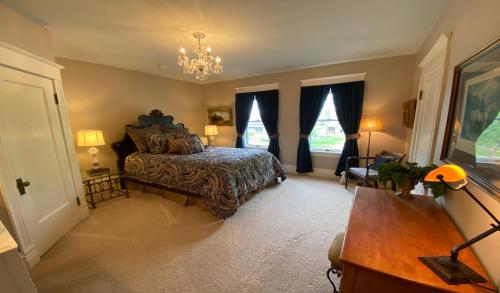 a bedroom with a bed and a desk and windows at Breese Inn in Breese