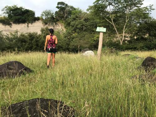 a woman walking through a field of tall grass at Waka Hotel Rural in Honda