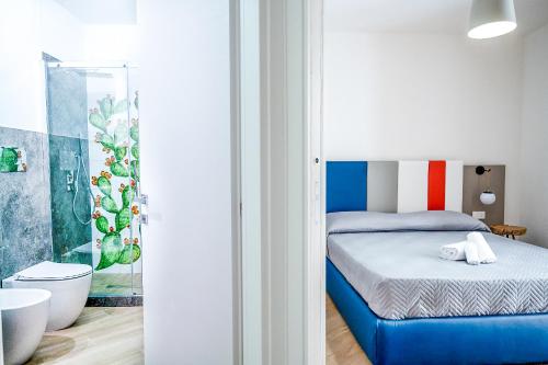 a small bedroom with a blue bed and a bathroom at Incao Holiday Giudecca House in Cefalù