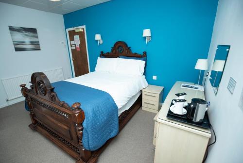 a bedroom with a bed and a desk at Le Maitre in Southport