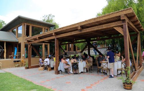 a group of people sitting at tables under a pavilion at SEL Lodge - Aventura y Descanso in San José de Maipo