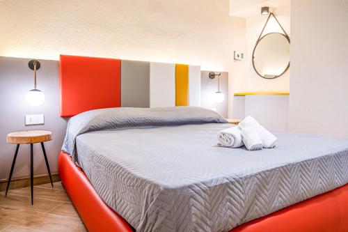 a bedroom with a bed with a red headboard and a mirror at Incao Holiday Candeloro House in Cefalù