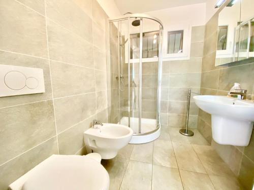 La salle de bains est pourvue de toilettes, d'un lavabo et d'une douche. dans l'établissement Appartamento Buresso, à Porto Valtravaglia