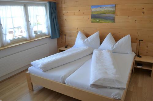 1 dormitorio con 1 cama con sábanas y almohadas blancas en Gasthaus Löwen, en Hemberg