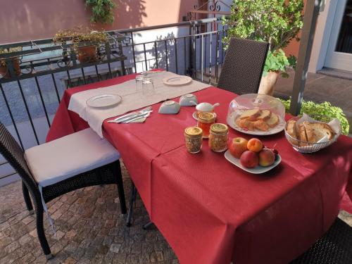 a table with a red table cloth with food on it at B&B Villa Dei Pini in Cannobio