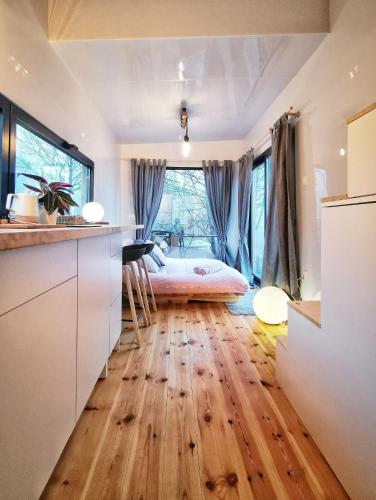 a bedroom with a bed and a wooden floor at LushHills - Tiny House - Modern House On Wheels in Regulice