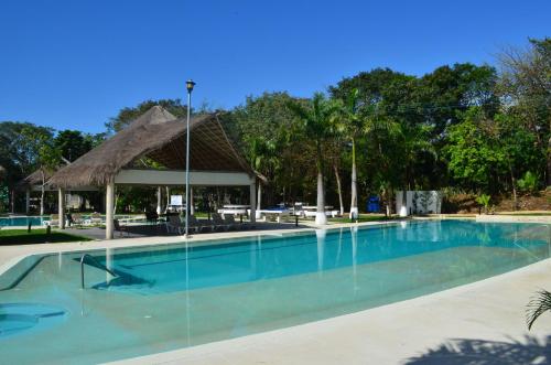 a large swimming pool with a gazebo at Ideal tu casa fuera de casa in Cancún