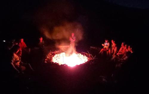 a crowd of people standing around a fire at night at SEL Lodge - Aventura y Descanso in San José de Maipo