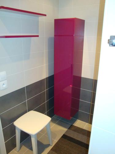 a bathroom with a stool and a red shower at LE CARRE MONTFORT in Vaison-la-Romaine