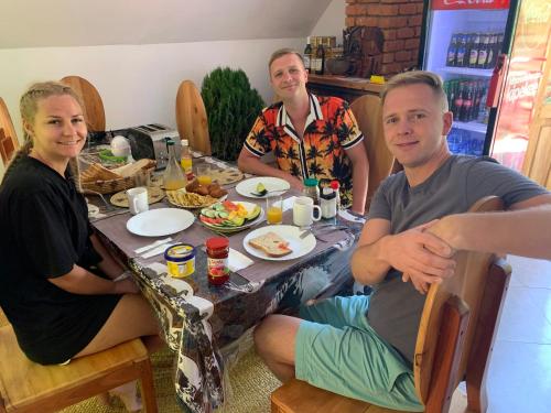 a group of people sitting around a table with food at David Crater Homestay in Lushoto