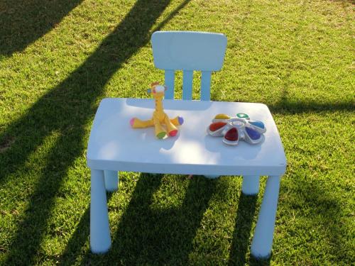 a blue chair with toys sitting on the grass at Elena Studios & Apartments in Piso Livadi