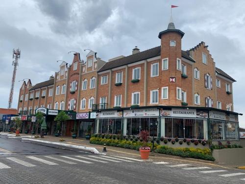 a large brick building on the side of a street at Apto Top Centrum Holambra/excelente localização in Holambra