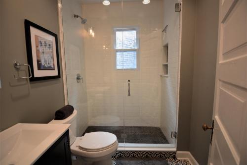 a bathroom with a shower with a toilet and a sink at Penthouse Level, Stunning Wrigley Stay in Chicago