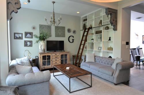 a living room with two couches and a television at Penthouse Level, Stunning Wrigley Stay in Chicago