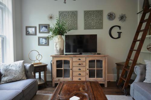 a living room with a tv on a wooden entertainment center at Penthouse Level, Stunning Wrigley Stay in Chicago