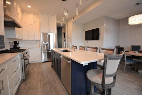 a large kitchen with a counter and a dining room at Penthouse Level, Stunning Wrigley Stay in Chicago
