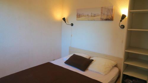 - une petite chambre avec un lit et deux lumières dans l'établissement Sol-y-Days Caraïbes piscine collective à deux pas des plages, au Grau-du-Roi