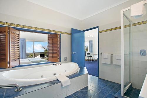 a large bathroom with a tub and a bedroom at Eagle Heights Mountain Resort in Eagle Heights