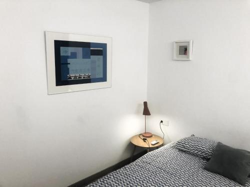 a bedroom with a bed and a table with a lamp at Art&Flats Hostel in Valencia