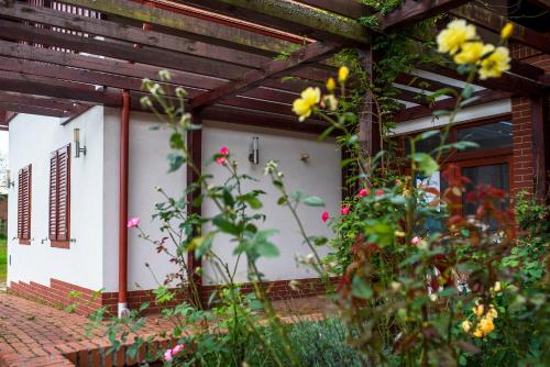 a front porch of a house with flowers at Naturpark Vendégház in Alsószölnök