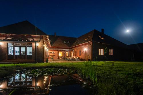 a house with a pond in front of it at night at Naturpark Vendégház in Alsószölnök