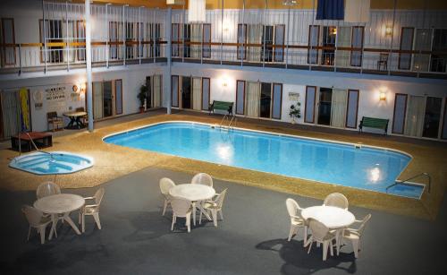 a large pool with tables and chairs in front of a hotel at Yogo Inn in Lewistown