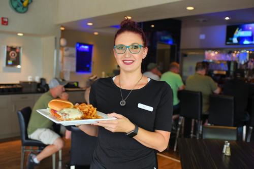 a woman holding a plate of food in a restaurant at Z Loft Extended Stay Hotel in Saint Robert