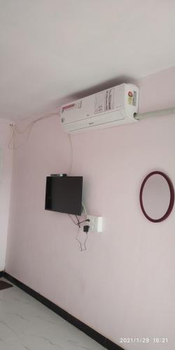 a white wall with a tv on a wall at Kulswami Cottage Alibag in Alibaug