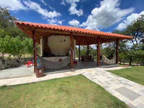 a pavilion with a hammock in a park at Chácara Recanto da Paz in Cavalcante