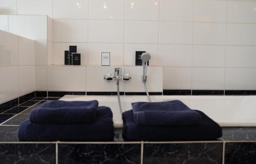 a bathroom with two blue pillows on the floor at Ellé'Belle Oudsbergen 1-, 2- or 3-Bedrooms in Oudsbergen 