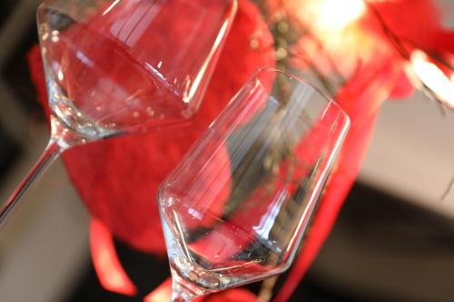 a pair of wine glasses next to a red vase at Ellé'Belle Oudsbergen 1-, 2- or 3-Bedrooms in Oudsbergen 