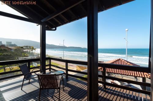 a view of the beach from the balcony of a house at Pousada Kia Ora Bombinhas in Bombinhas