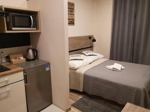a small room with a bed and a microwave at Hotel 1 in Płock