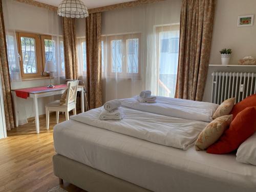 a bedroom with a large bed and a desk in it at Ferienwohnung Magdalena - ruhig, zentral, schöne Sonnenterrasse in Schliersee