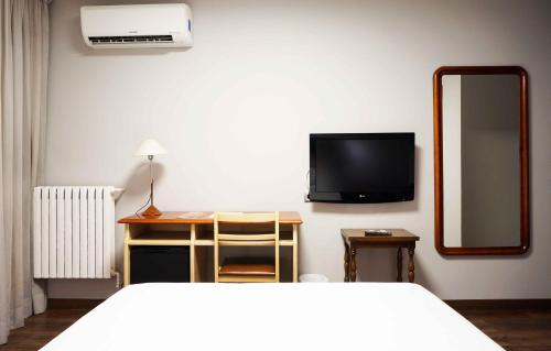 a bedroom with a bed and a mirror and a tv at Cesaraugusta in Zaragoza
