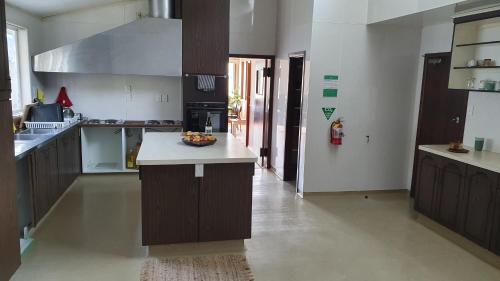 a kitchen with brown cabinets and a bowl of fruit on a counter at The Headland Lodge in Gisborne