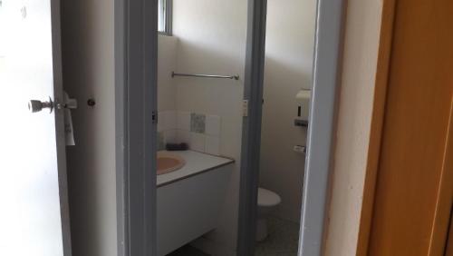 a white bathroom with a sink and a toilet at Collie Motel in Collie