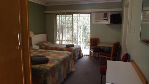 a hotel room with two beds and a window at Collie Motel in Collie