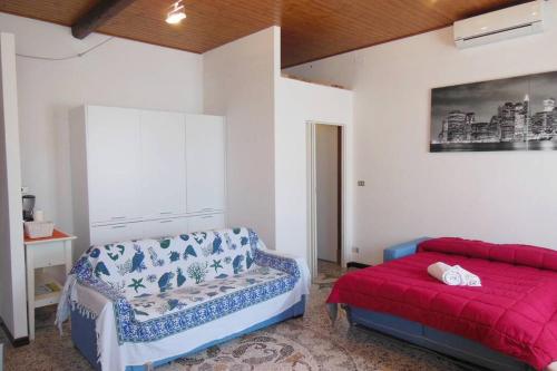 1 dormitorio con cama roja y sofá en Mare nostrum apartment en Lavagna