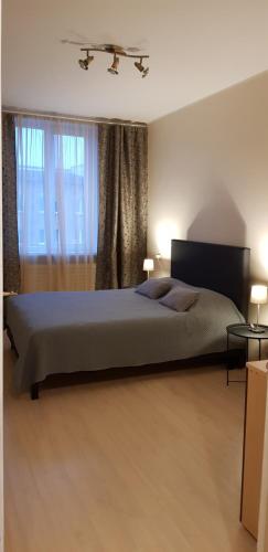 a bedroom with a large bed and a window at Castle View Apartment in Narva