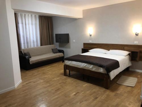 a bedroom with a bed and a chair and a couch at Vila LOFT CUBE in Sinaia
