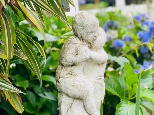 a statue of a couple hugging in a garden at Caribe Accommodation and Conferences in Pietermaritzburg