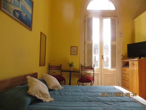 - une chambre avec un lit doté d'oreillers et d'une fenêtre dans l'établissement Hostal El Rincon Marino, à Valparaíso