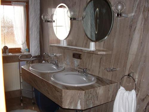 a bathroom with two sinks and a large mirror at Haus Obermayer in Laufen