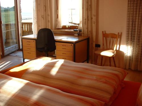 una camera con letto, scrivania e sedia di Haus Obermayer a Laufen