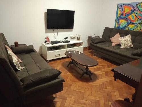sala de estar con 2 sofás y TV de pantalla plana en Conforto em Copacabana, en Río de Janeiro