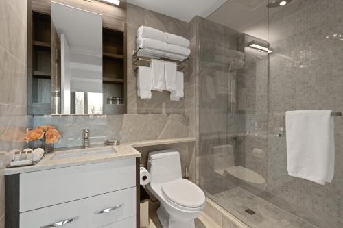 a bathroom with a toilet and a glass shower at SOHO Residences Champagne in Ottawa