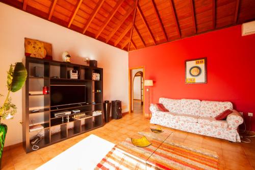 a living room with a couch and a red wall at Villa Tamanca in El Paso