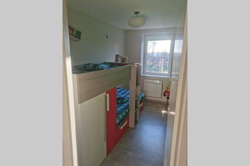 Cette petite chambre comprend des lits superposés et une fenêtre. dans l'établissement Au bord de l'eau, à Charentenay