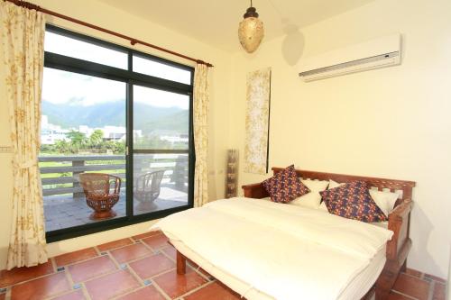 a bedroom with a bed and a large window at Mandheling B&B in Jian